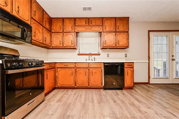 a kitchen with stainless steel appliances granite countertop a stove a sink and a microwave