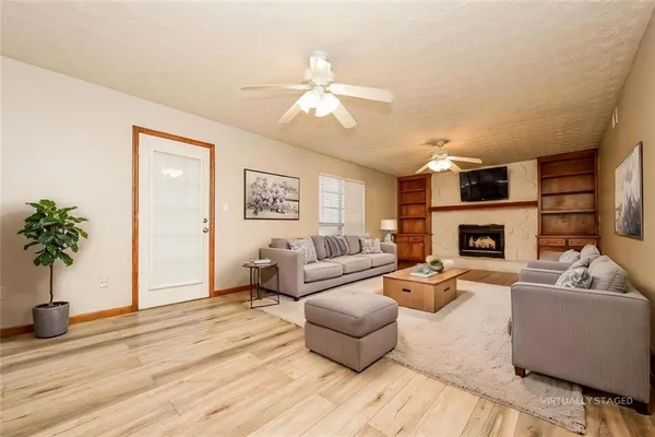 a living room with furniture a fireplace and a potted plant