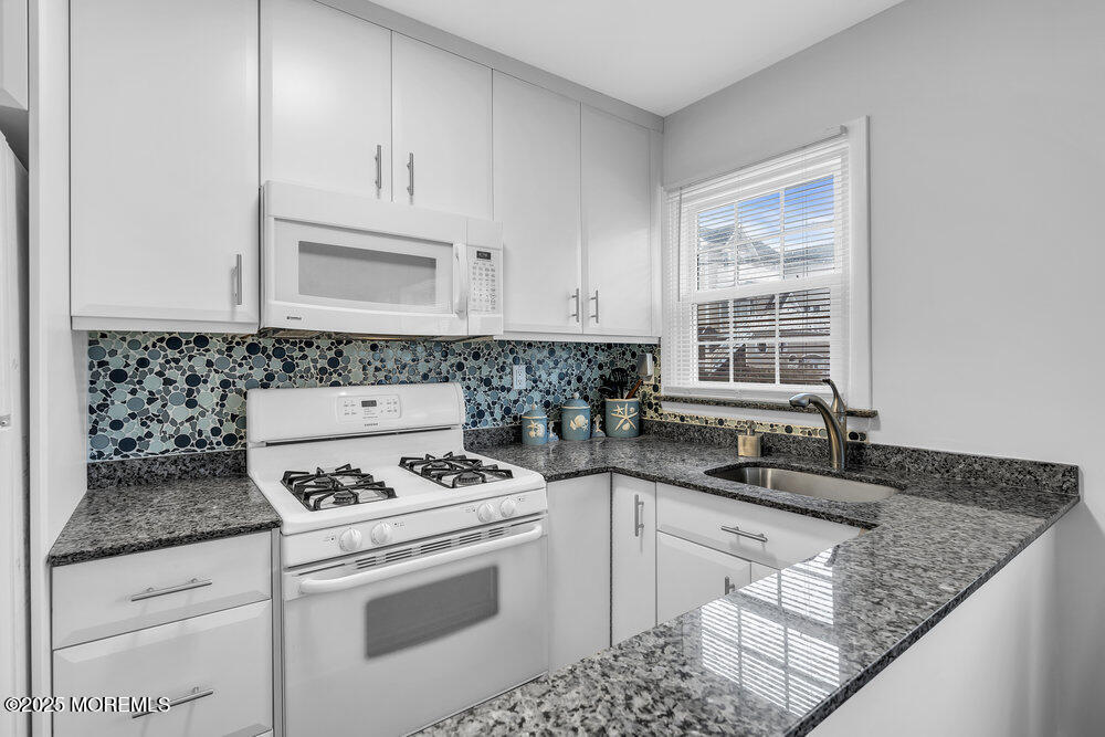 1304 Ocean Avenue, Unit 2A Belmar, NJ 07719 - Photo 11 of 25 a kitchen with granite countertop a sink stove and cabinets