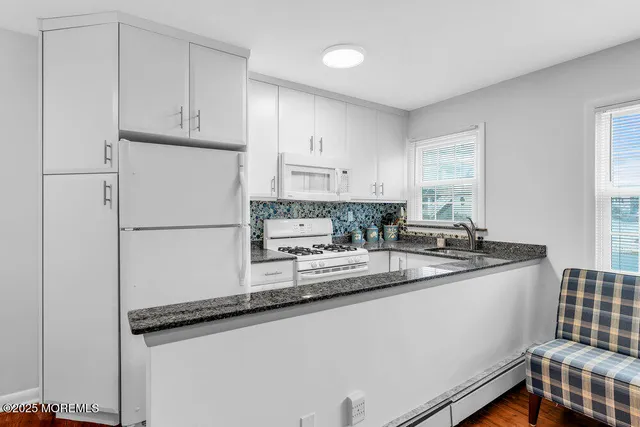 a kitchen with stainless steel appliances granite countertop a refrigerator sink and white cabinets