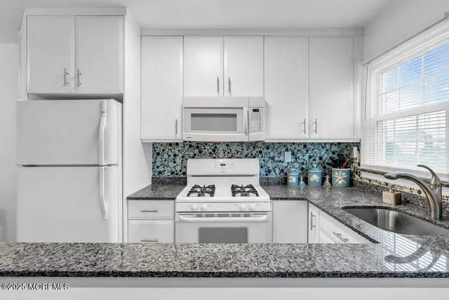a kitchen with a stove a refrigerator and a sink