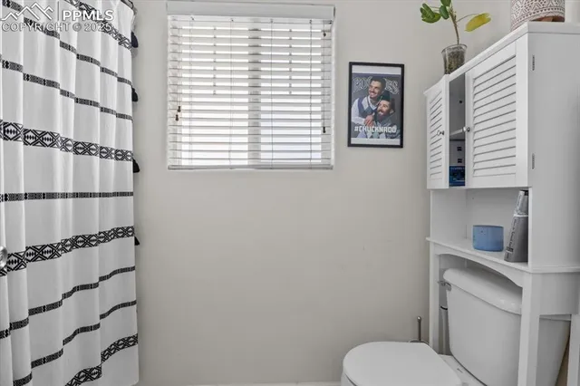a bathroom with a toilet and a shower curtain