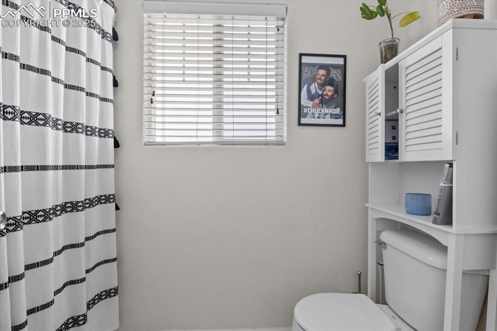 1649 Reilly Grove Colorado Springs, CO 80951 - Photo 12 of 20 a bathroom with a toilet and a shower curtain