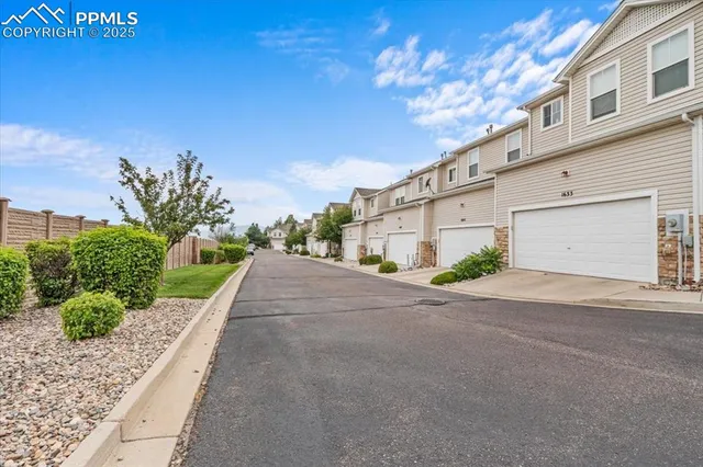 a house with a yard and a car park in front of it