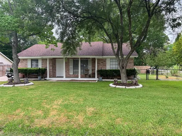 a front view of a house with a garden and trees