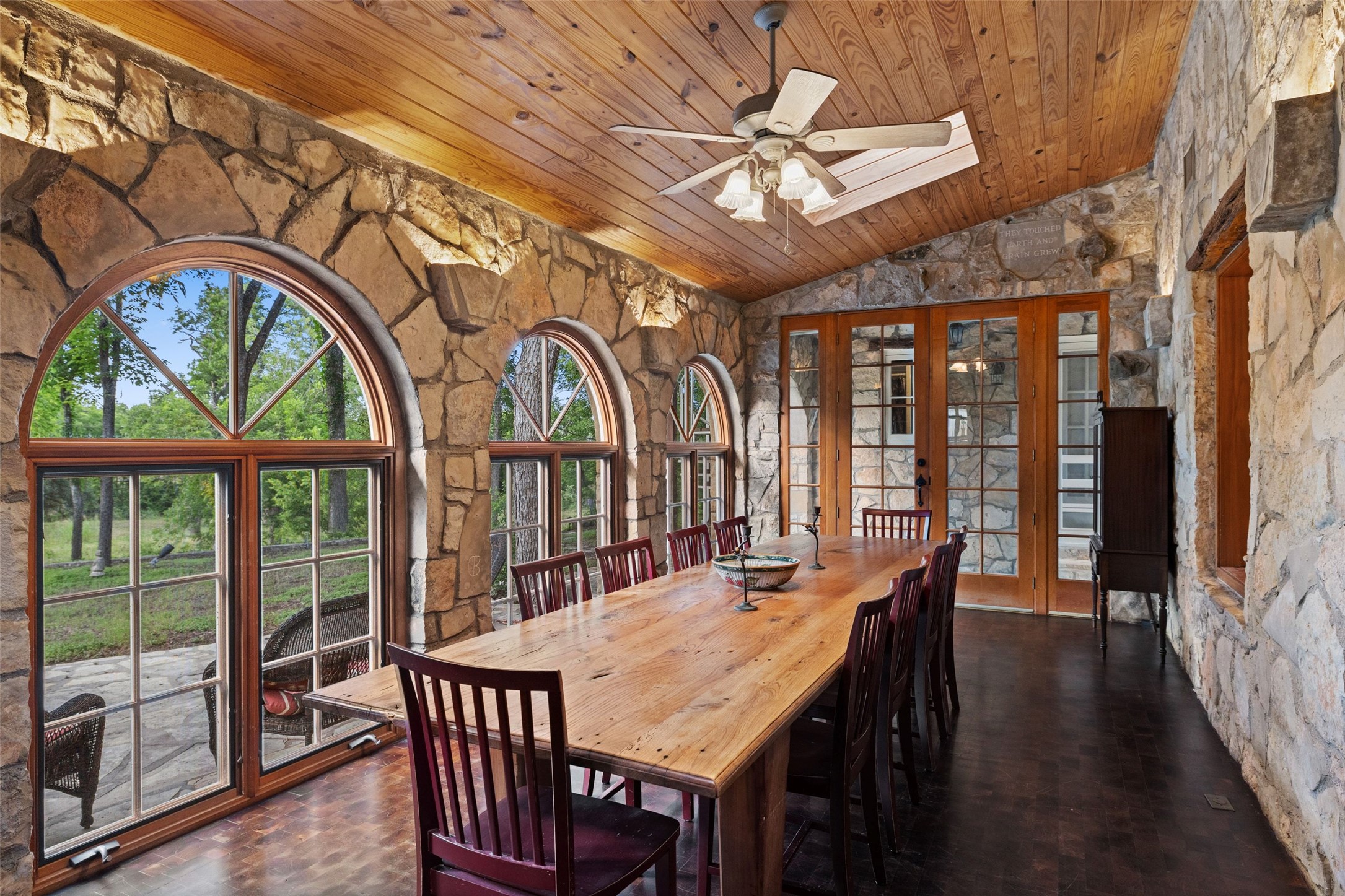 505 Red Corral Ranch Road Wimberley, TX 78676 - Photo 26 of 40 Stone walls and vast arched windows define this unique, nature-immersed dining room.