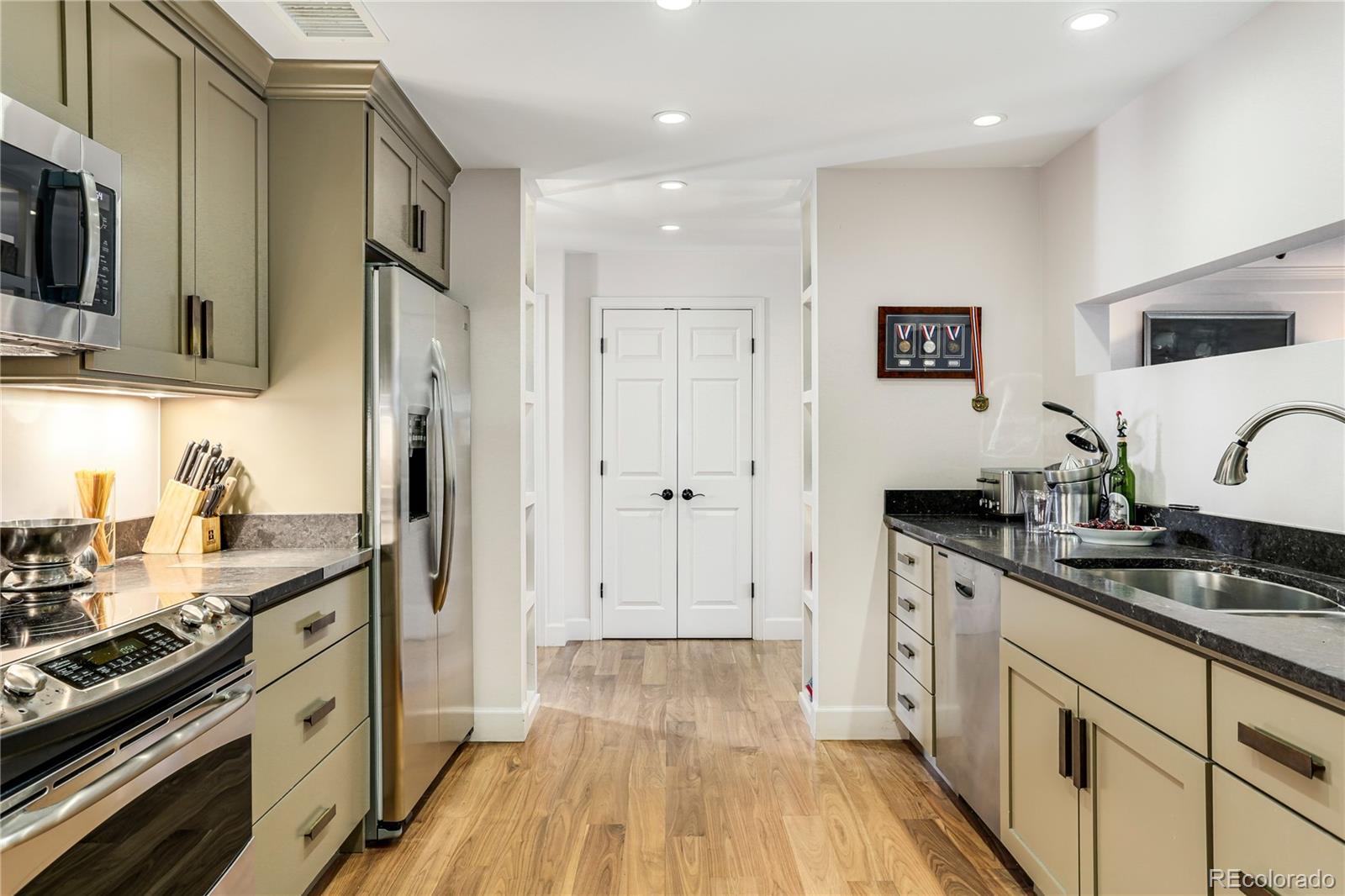 1133 Race Street, Unit 5A Denver, CO 80206 - Photo 11 of 33 a kitchen with stainless steel appliances a sink stove and refrigerator