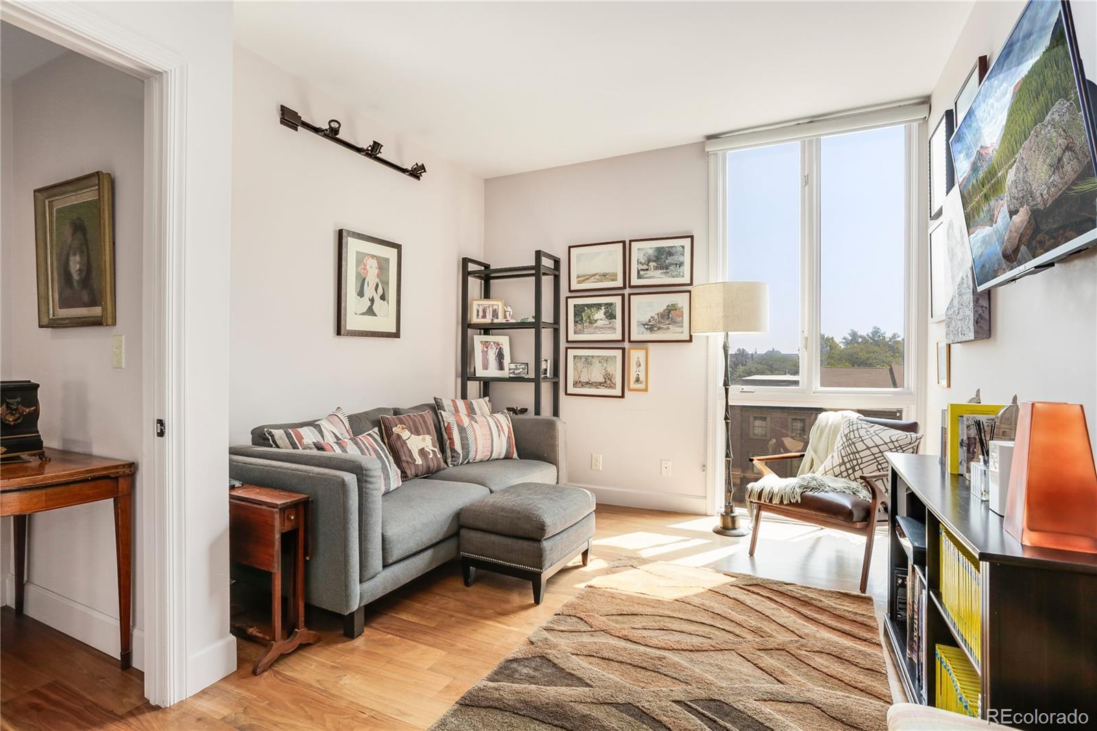 1133 Race Street, Unit 5A Denver, CO 80206 - Photo 14 of 33 a living room with furniture and a floor to ceiling window