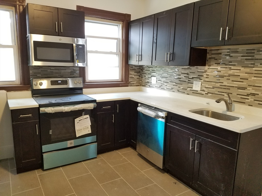 98 Topliff Street, Unit 2 Boston, MA 02122 - Photo 1 of 11 a kitchen with a sink stove and microwave