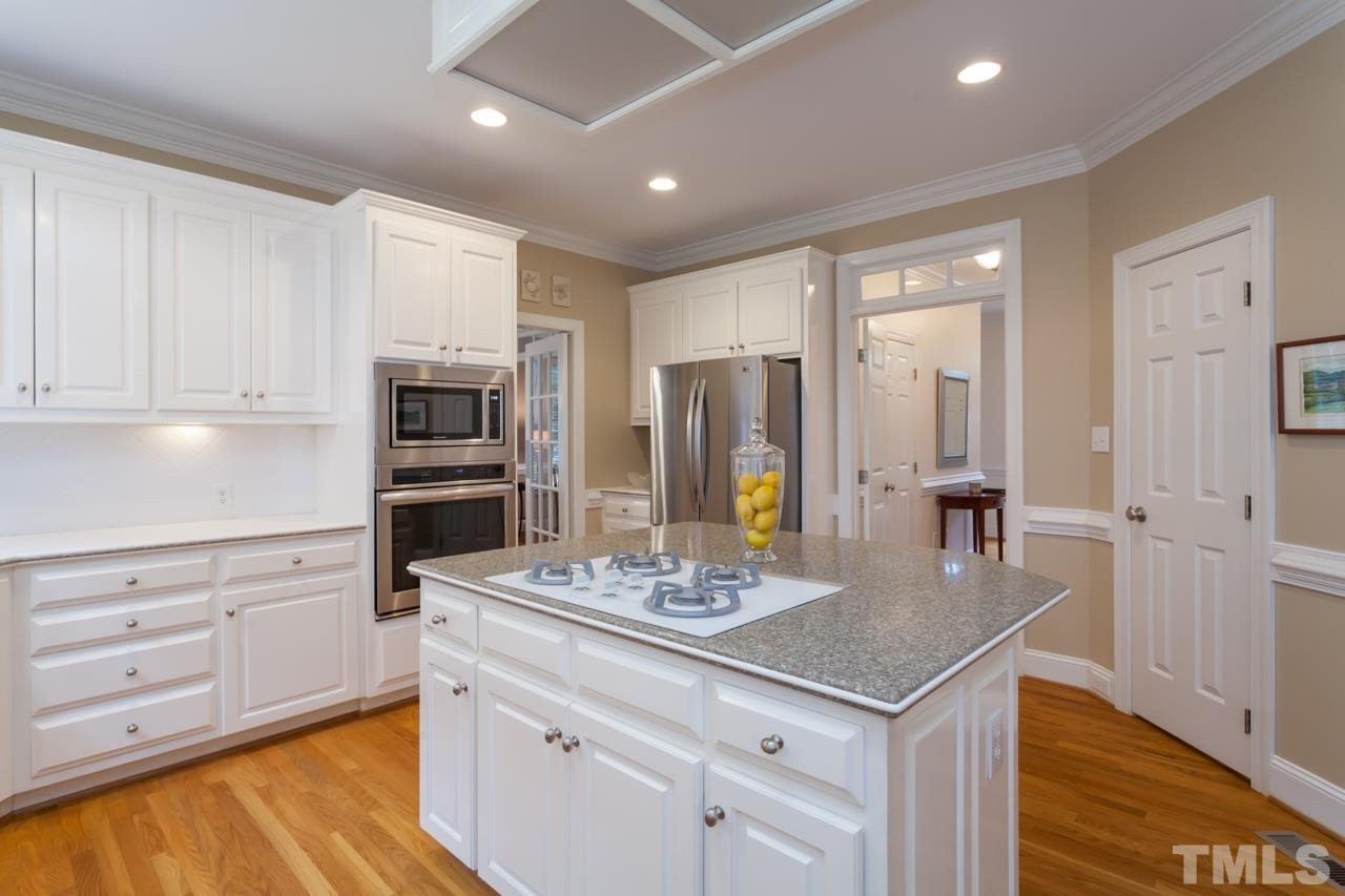 3709 White Chapel Way Raleigh, NC 27614 - Photo 10 of 25 The kitchen offers a large work island and wonderful walk-in pantry. The white cabinets and white tile back splash are crisp and clean. Kitchen