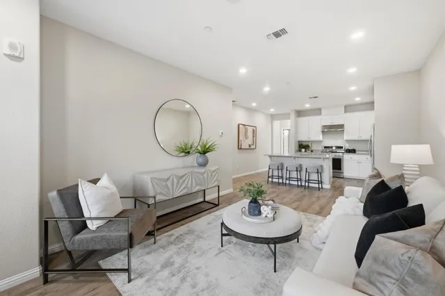 a living room with furniture and a wooden floor