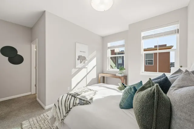 a bed sitting in a bedroom next to a window and a chandelier