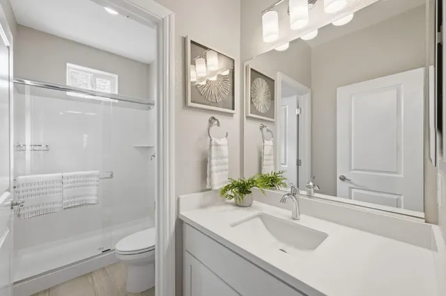 a bathroom with a sink a toilet and shower