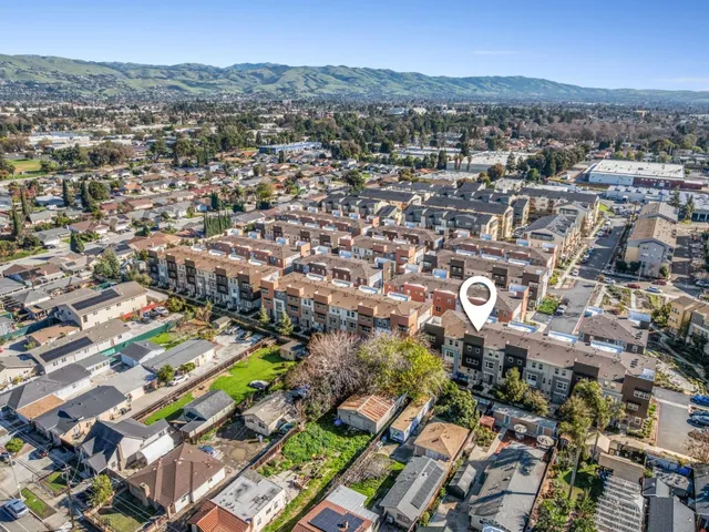 an aerial view of residential building with outdoor space and trees