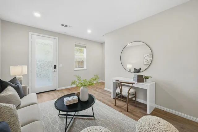 a living room with furniture a mirror and a potted plant