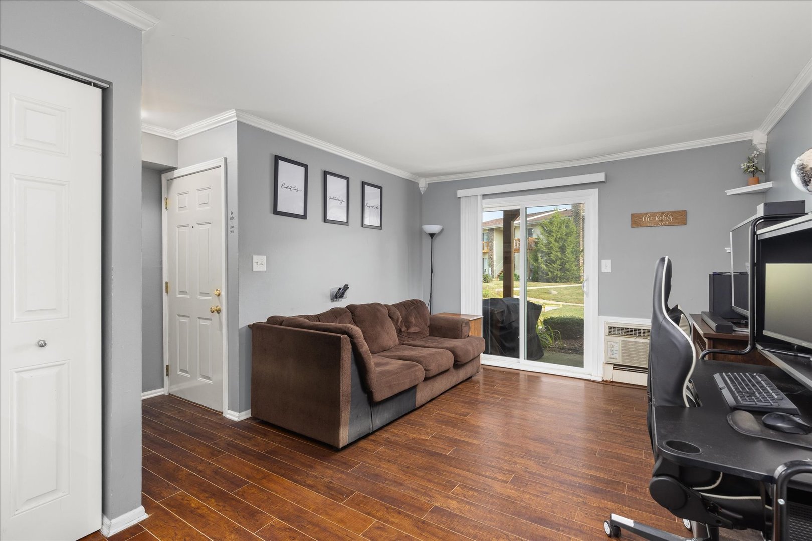 2400 Light Road, Unit 111 Oswego, IL 60543 - Photo 5 of 27 a living room with furniture a flat screen tv and wooden floor