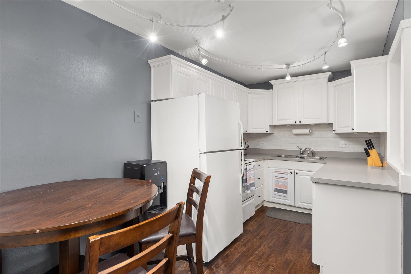 2400 Light Road, Unit 111 Oswego, IL 60543 - Photo 9 of 27 a kitchen with stainless steel appliances granite countertop a stove a refrigerator a sink dishwasher a dining table and chairs with wooden floor