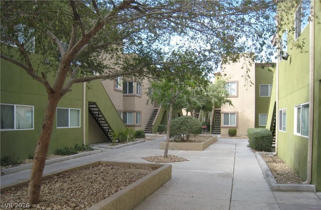 1844 North Decatur Boulevard, Unit 204 Las Vegas, NV 89108 - Photo 2 of 8 A tranquil courtyard features mature trees, landscaped planters, and well-maintained pathways connecting residential buildings.