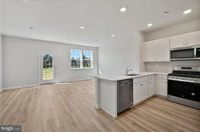 a kitchen with granite countertop a stove top oven sink and cabinets