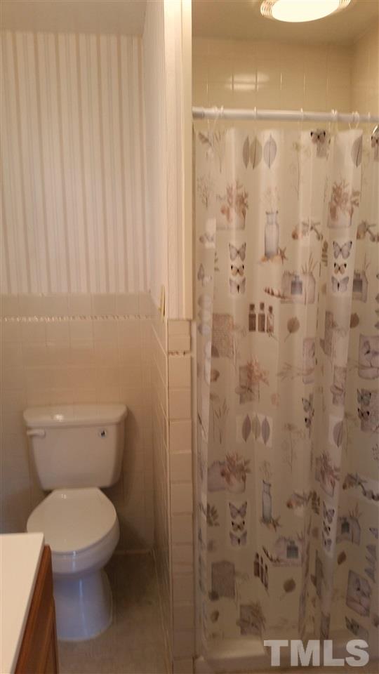 375 Burlington Road Roxboro, NC 27573 - Photo 11 of 11 a white toilet sitting next to a shower curtain
