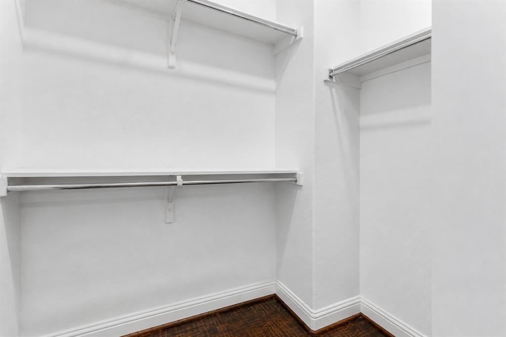 5744 Robbie Road Plano, TX 75024 - Photo 25 of 32 Walk-in closet featuring white wire shelving, chrome hanging rods, wood-finish flooring, and white baseboards