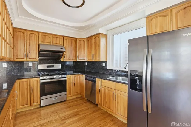 a kitchen with stainless steel appliances granite countertop a stove and a sink