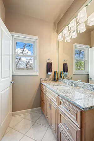 a bathroom with a granite countertop sink a large mirror and a window