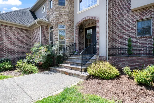 a front view of a house with a yard and potted plants