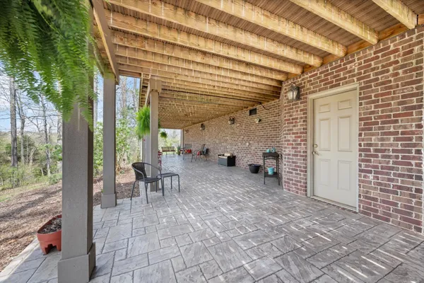a view of a patio with table and chairs and couches with wooden floor and fence