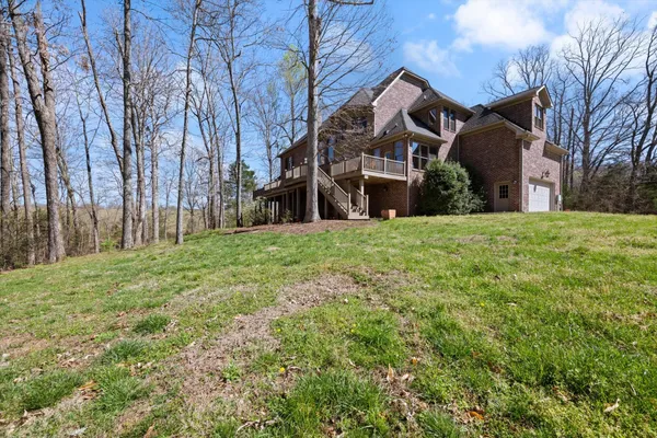 an aerial view of a house with a yard and large trees