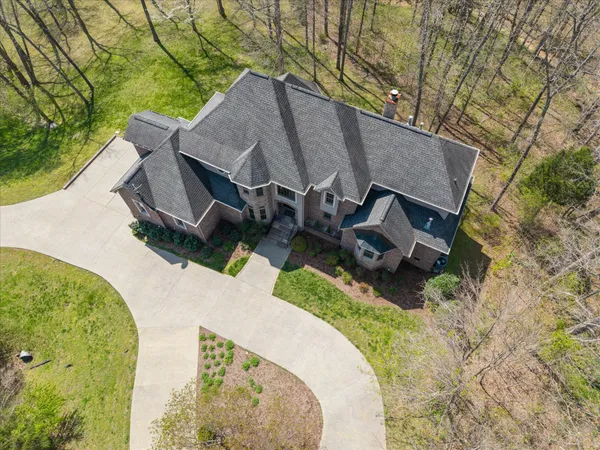 a view of a big house with a big yard and large trees