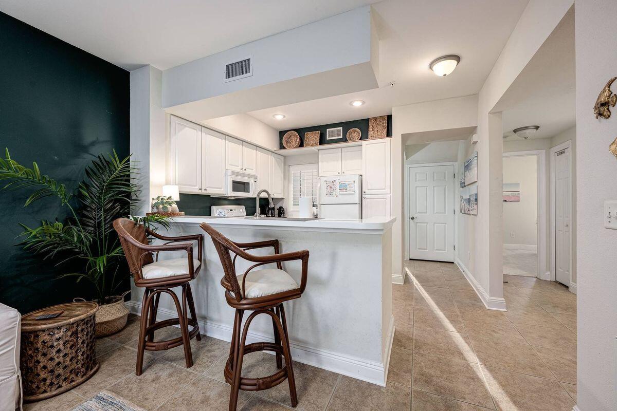 124 Village Boulevard, Unit 813 Santa Rosa Beach, FL 32459 - Photo 5 of 19 a kitchen with stainless steel appliances kitchen island granite countertop furniture and a refrigerator