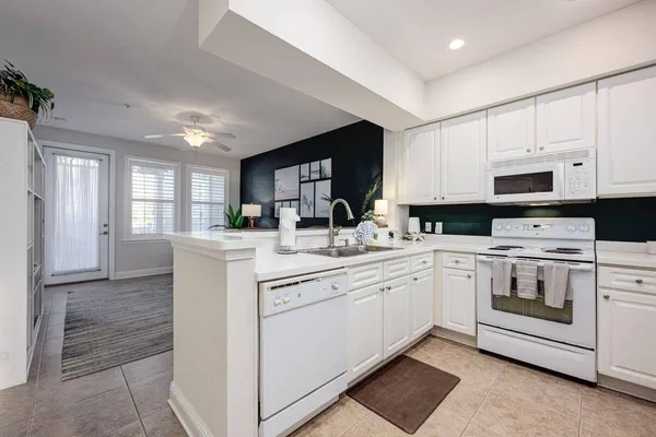 a kitchen with white cabinets and white appliances