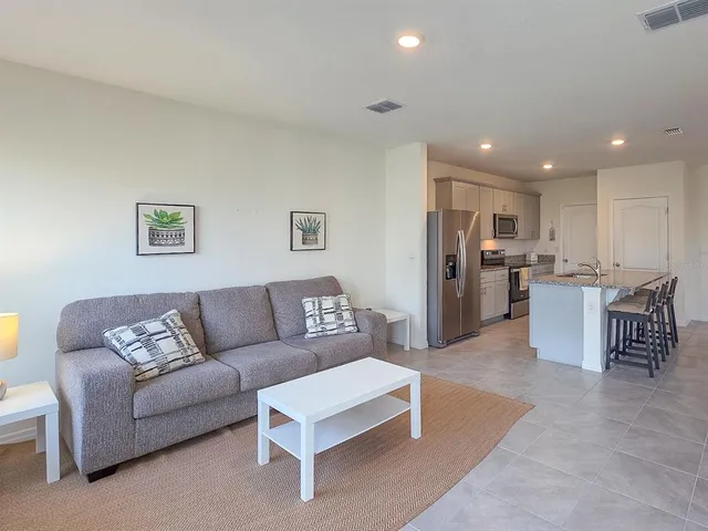 a living room with furniture and kitchen view