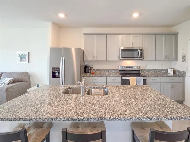 a kitchen with stainless steel appliances granite countertop a sink stove and refrigerator