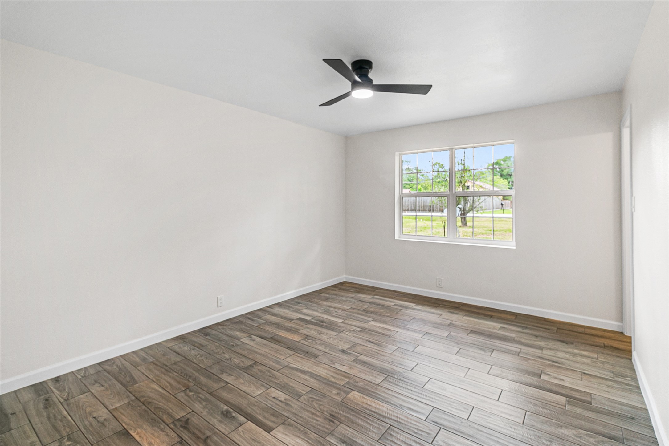 16715 Waycreek Road Houston, TX 77068 - Photo 11 of 41 a view of an empty room with wooden floor and a window
