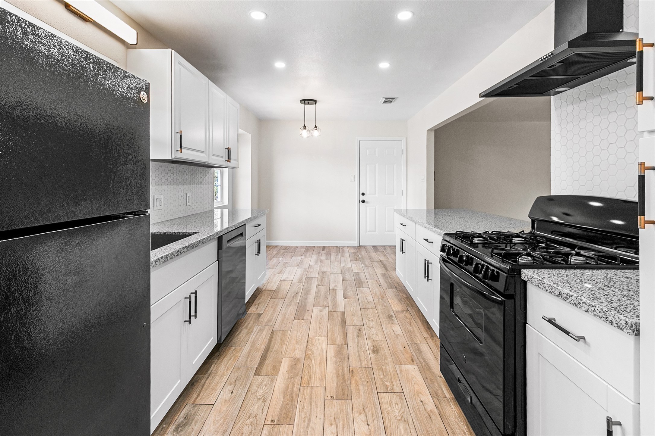 16715 Waycreek Road Houston, TX 77068 - Photo 8 of 41 a kitchen with granite countertop a refrigerator oven a sink and white cabinets