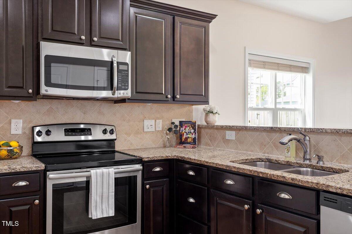 632 Hunters Ridge Drive Fuquay-Varina, NC 27526 - Photo 12 of 28 a kitchen with granite countertop a sink stove and microwave