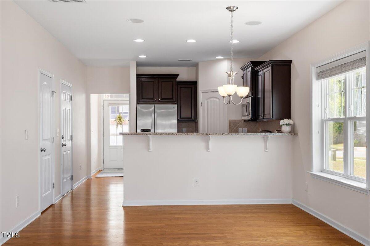 632 Hunters Ridge Drive Fuquay-Varina, NC 27526 - Photo 13 of 28 a view of a kitchen with a refrigerator wooden floor and a window