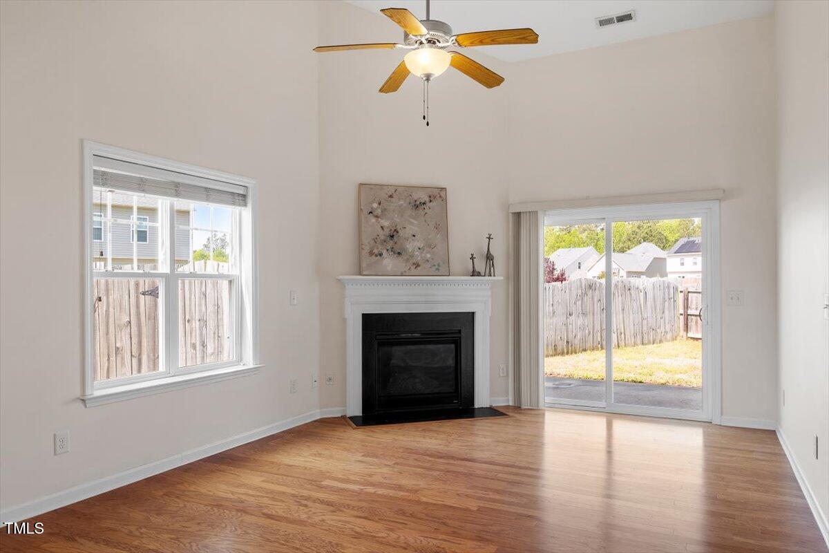 632 Hunters Ridge Drive Fuquay-Varina, NC 27526 - Photo 16 of 28 wooden floor fireplace and windows in an empty room