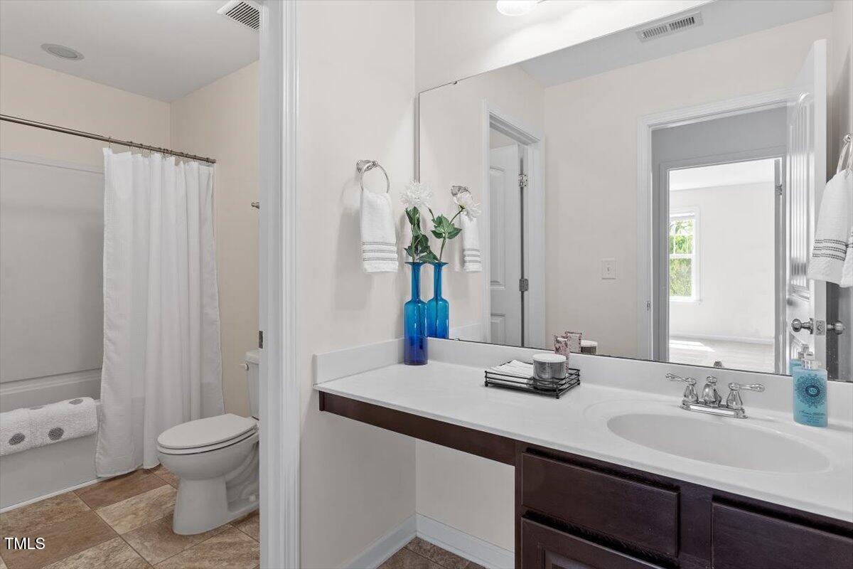 632 Hunters Ridge Drive Fuquay-Varina, NC 27526 - Photo 26 of 28 a bathroom with a granite countertop sink a toilet and a mirror