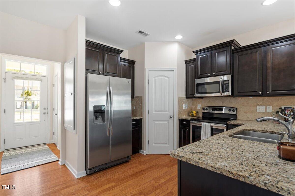 632 Hunters Ridge Drive Fuquay-Varina, NC 27526 - Photo 9 of 28 a kitchen with stainless steel appliances granite countertop a refrigerator a sink a stove a microwave and island