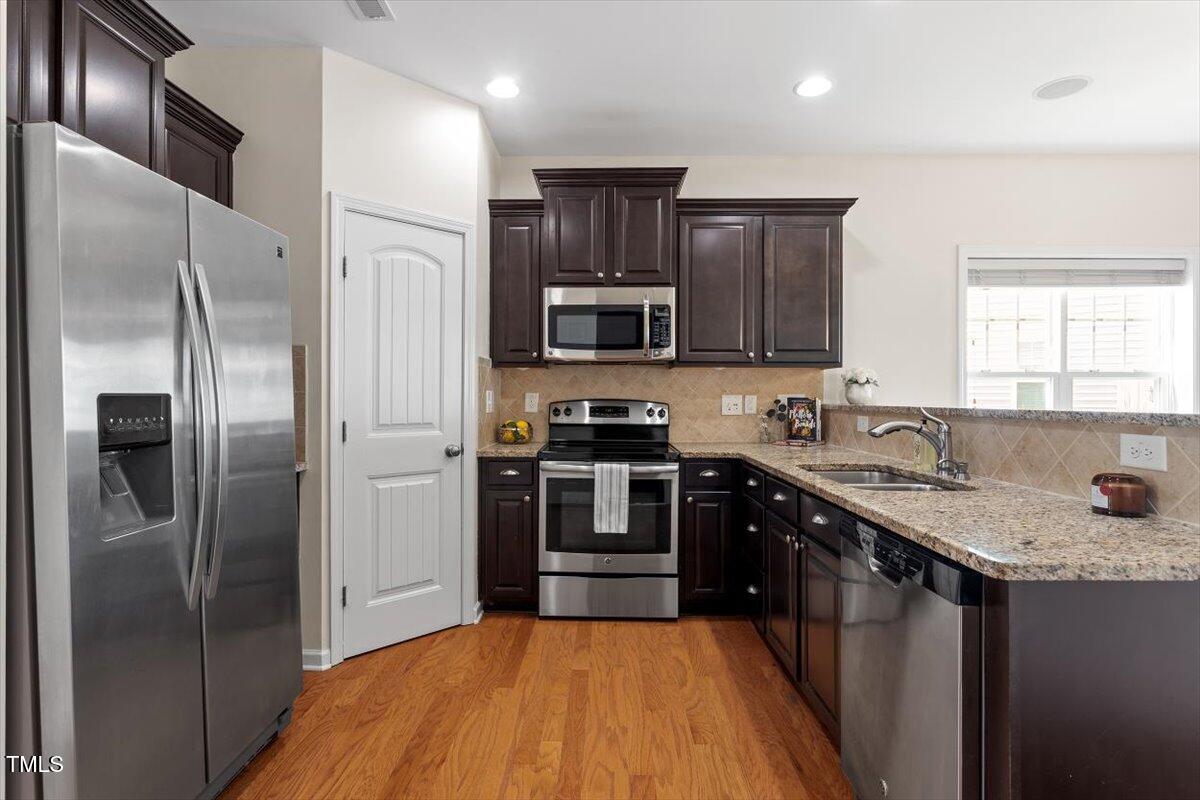 632 Hunters Ridge Drive Fuquay-Varina, NC 27526 - Photo 10 of 28 a kitchen with stainless steel appliances granite countertop a stove refrigerator and a sink