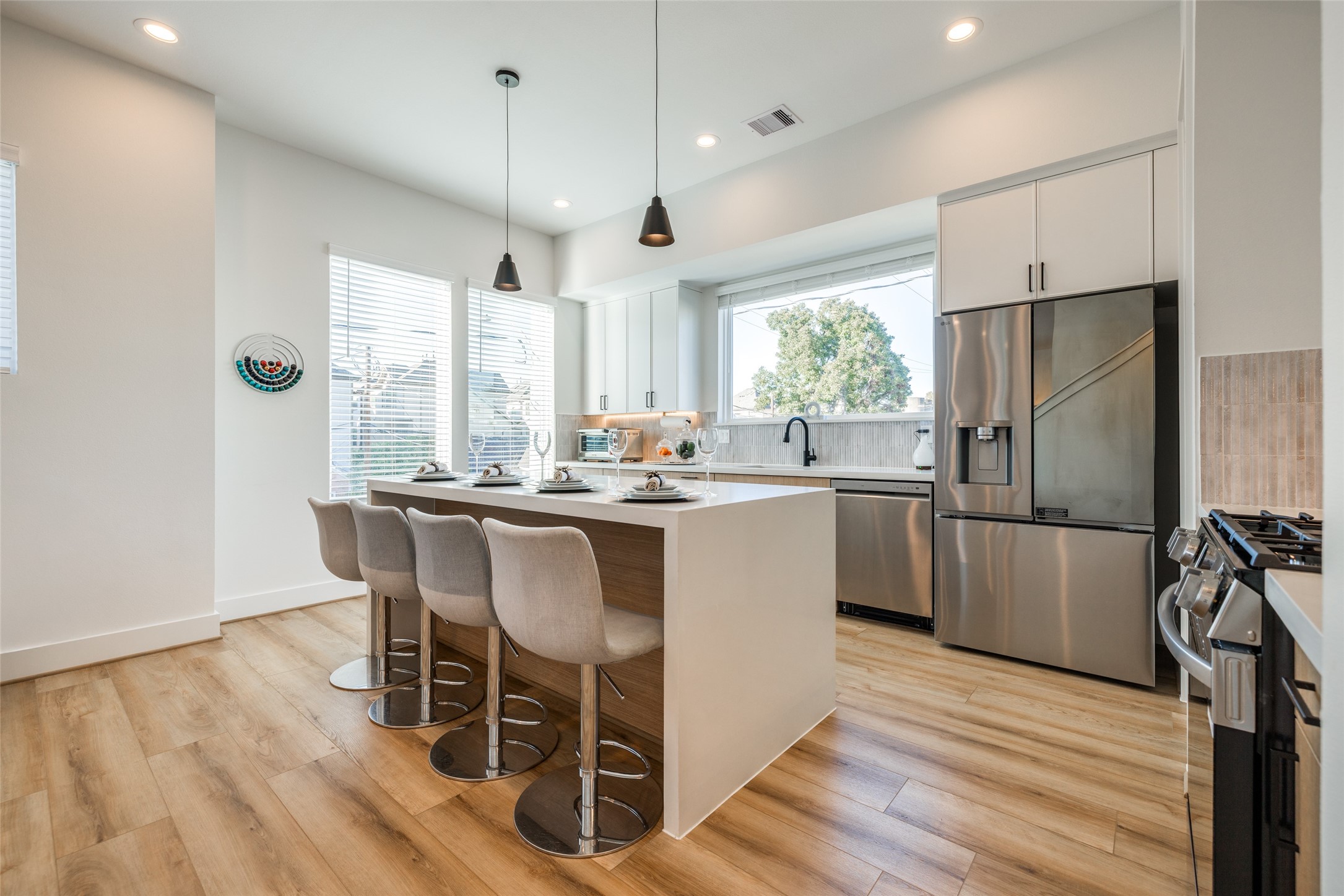 412 North Nagle Street Houston, TX 77003 - Photo 11 of 40 a kitchen with stainless steel appliances granite countertop a refrigerator a sink dishwasher a stove and white countertops with wooden floor