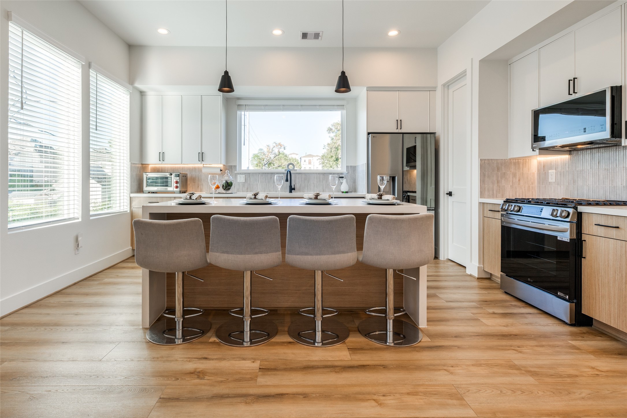 412 North Nagle Street Houston, TX 77003 - Photo 12 of 40 a kitchen with stainless steel appliances granite countertop a stove top oven a sink dishwasher a dining table and chairs with wooden floor