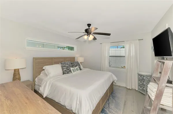 a bedroom with a large bed and a chandelier