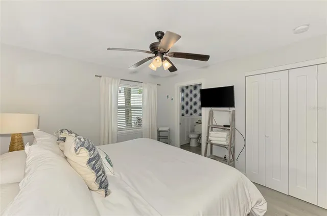 a bedroom with a large bed and a chandelier