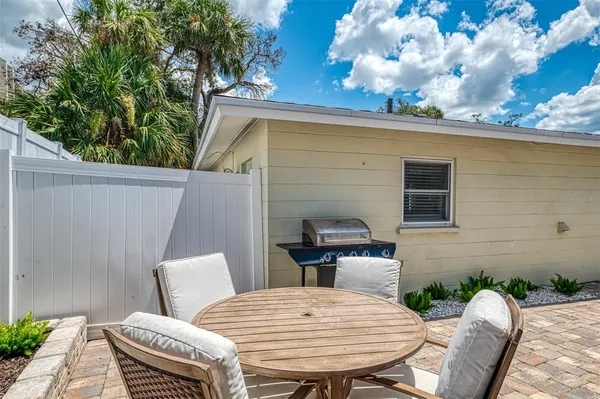 a backyard of a house with barbeque oven table and chairs
