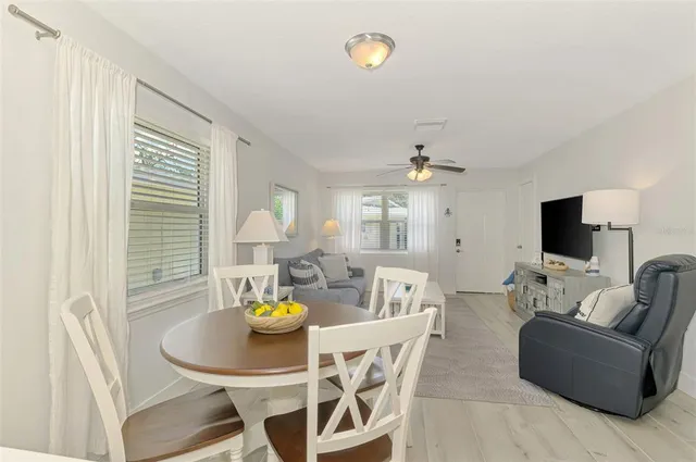 a living room with furniture a flat screen tv and a dining table