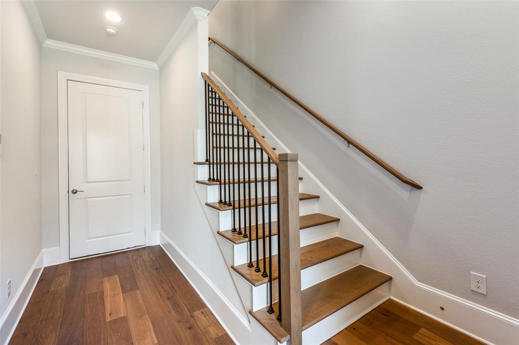 5421 Patterson Street Irving, TX 75039 - Photo 11 of 32 Staircase featuring wood-finish treads and handrails, black metal balusters, and white risers